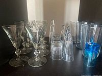 Assorted glassware showing stemmed glasses, shot glasses, tumblers and blue tumbler