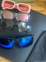 Stacked view four pairs showing lens colors and frame styles