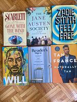 Front covers of all six books laid flat on parquet floor