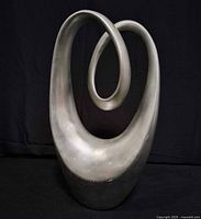 front view of silver abstract infinity loop sculpture