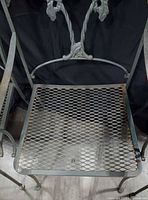 Full view of chair showing mesh seat and decorative back