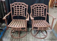 Two cast metal swivel rocking chairs side by side