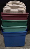 Stacked view of four visible totes—maroon, forest green, light teal, blue—with off-white lids placed on top