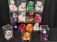 Full group of 12 display cases stacked plus three cases at front showing pastel unicorn, green bear, star bear, orange cat, empty lidless case