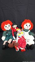 Group shot of Raggedy Ann, Raggedy Andy, Olive Oyl plush and clown doll