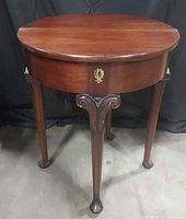 Full view of table opened to round showing legs and top