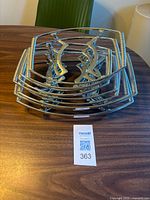 Stacked view of nine oval metal trivets