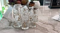 Seven matching highball glasses on countertop