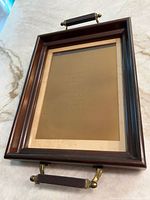 Angled view of framed engraving plate with brass handles and visible mat spotting
