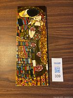 Full view of ceramic tile artwork placed on table with QR tag