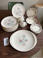 All dinnerware pieces arranged on table including platter, plates, mugs, bowls