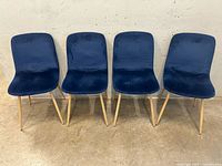 Front view of the four navy velvet chairs aligned