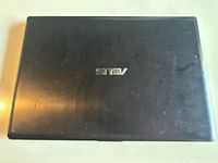 Closed Asus laptop showing black lid with logo