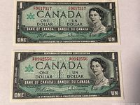 Front view of two 1967 Canadian one-dollar notes showing serial numbers and Centennial text