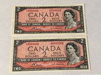 Two 1954 Canada $2 notes laid flat, obverse side showing Queen Elizabeth II, serial numbers visible