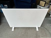 Front view of white DeLonghi panel heater on feet