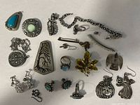 Full layout of twenty-one assorted jewellery pieces on flat surface