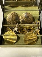 Drawer showing multiple gold-tone earrings pair sets and single cat earring