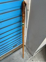 Full view of wooden cane showing length and badge placement