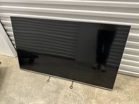 Front view of Samsung 55-inch flat screen TV leaning against wall