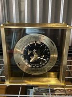 Front view of Seiko world time desk clock in brass frame