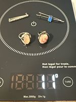 Group view of four sterling silver jewellery pieces on scale reading 16.81 g