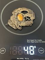 Pendant on digital scale showing weight 48 g