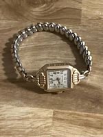 Full view of wristwatch with expansion band on wood surface