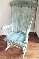 Full view of distressed light blue wooden rocking chair