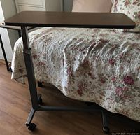 Full view of bedside rolling table next to bed