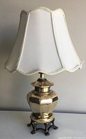 Full view of brass table lamp with white shade