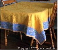 Tablecloth draped over table showing yellow center and blue olive border