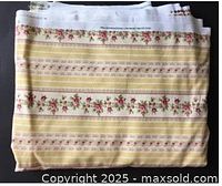 Folded yellow floral stripe upholstery fabric showing overall pattern