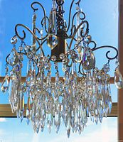 Full view of assembled brass and crystal chandelier against window