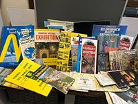 Front view showing assorted booklets and maps including CNE 1954 program, Calgary brochures, Klondike Day pamphlet, Alberta and Manitoba guides