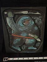 Front view of polystone Inuit Hunter plaque with scale