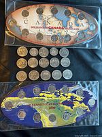 Full view of both Millennium quarter sets in plastic sleeves with loose commemorative coins below