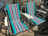 Pair of striped aluminum beach chairs on deck
