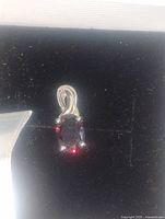 Front view of sterling silver pendant with oval garnet
