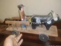 Side view of carved horse, wagon and man showing overall structure