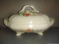 Front view of cream floral footed covered dish
