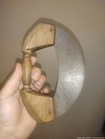 Front view of ulu showing blade curve and wood handle blocks