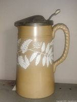 Full view left side showing fern relief, pewter lid and handle