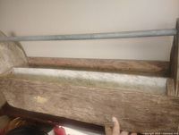 Full view of wooden toolbox showing metal handle, weathered wood, interior and exterior surfaces