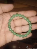 Bracelet displayed in hand showing size, bead shape and color