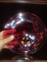 front view of cranberry glass bowl held by hand
