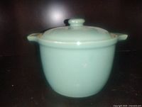 Front view of teal stoneware crock with lid