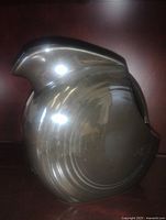 Front view of black disc pitcher showing glossy glaze and shape