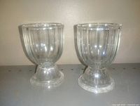 Front view of two matching clear glass egg cups standing upright