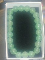 Top view of entire green aventurine bead bracelet in display box